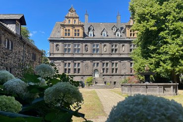 Ansicht eines alten, eleganten Gebäudes mit Blumen im Vordergrund