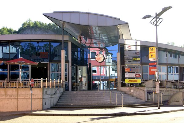 Eingang zu einem modernen Gebäude mit reflektierenden Fenstern und Uhr