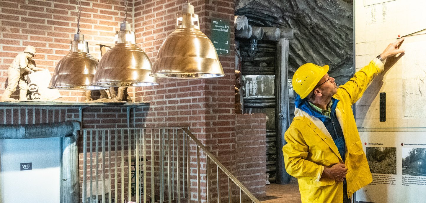 Am Eingang der Grube Bindweide erklärt ein Gästeführer den Besuchern den schematischen Aufbau der Grube