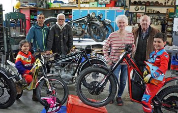 Gerhard Weller und seine Frau Agnes stehen mit einer Familie zwischen den Motorrädern im Museum