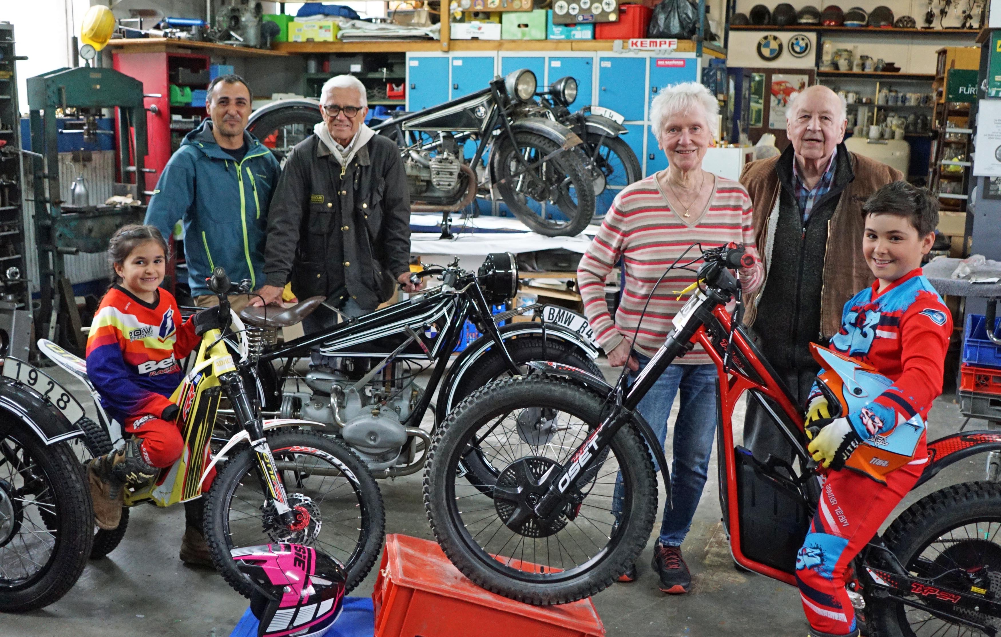 Gerhard Weller und seine Frau Agnes stehen mit einer Familie zwischen den Motorrädern im Museum