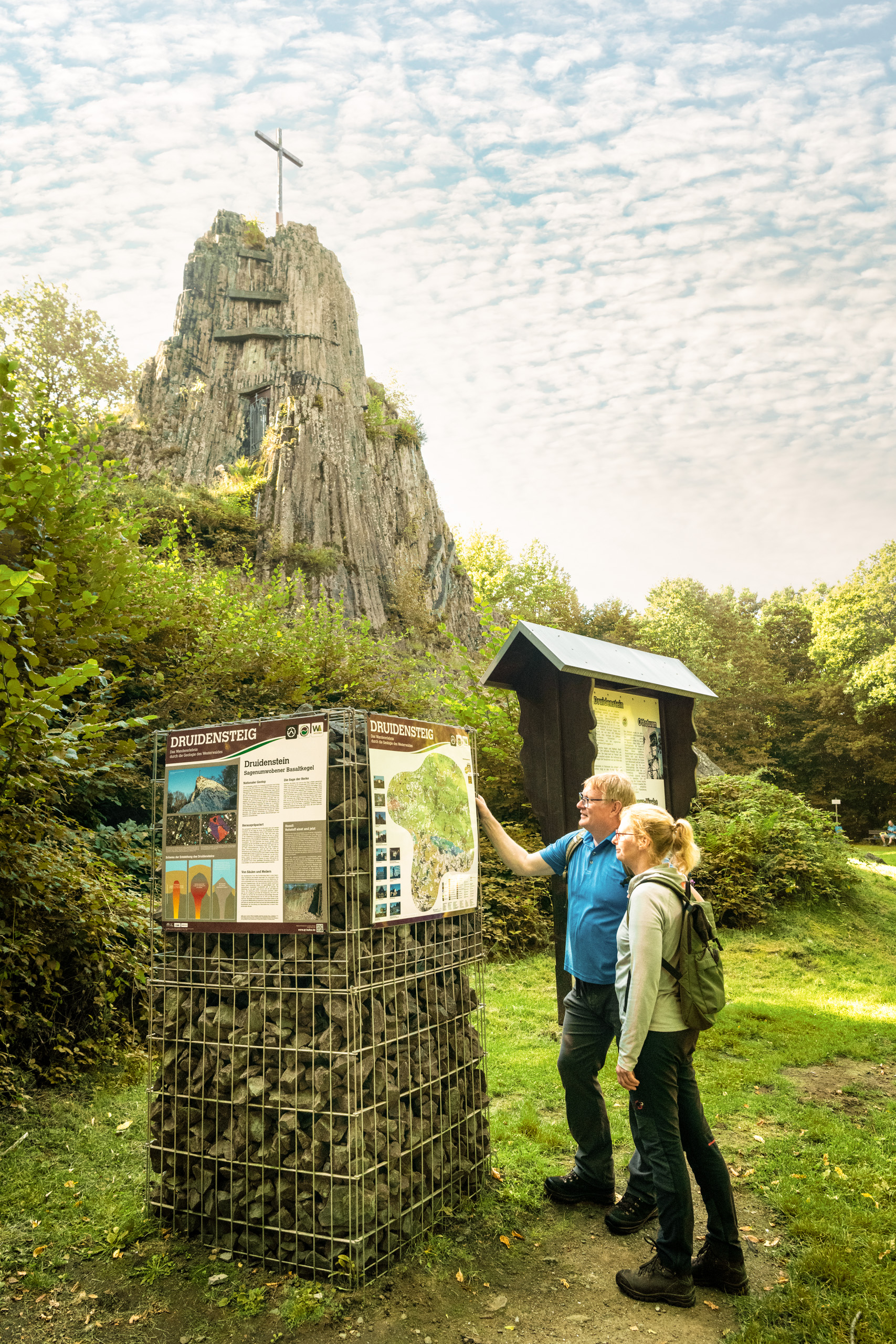 Zwei Wanderer stehen vor einer Wandertafel am Druidenstein