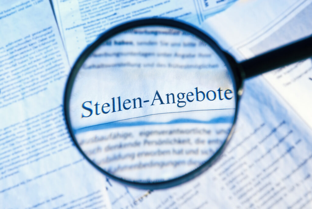 Fokus auf Stellenangebote in Zeitungsanzeigen durch eine Lupe